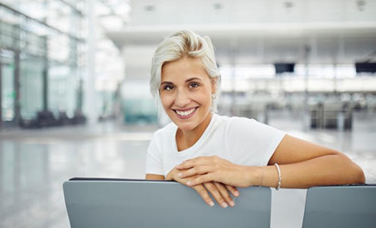 Woman sitting in airport smiling
