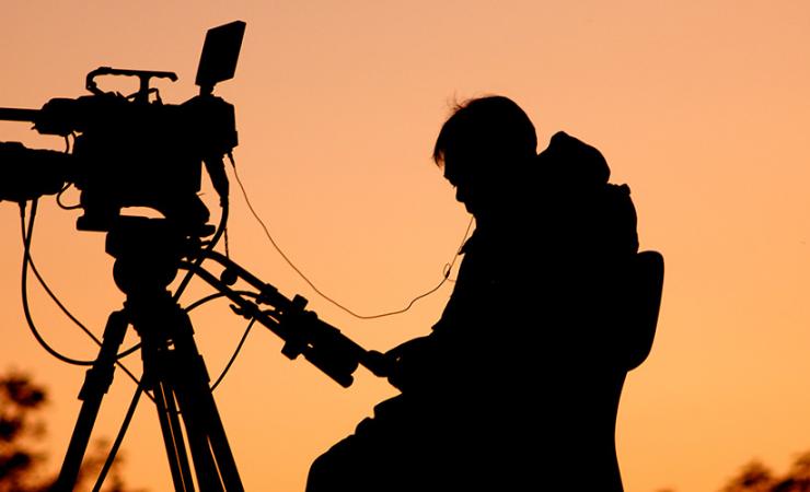Silhouette of camera man at sunset