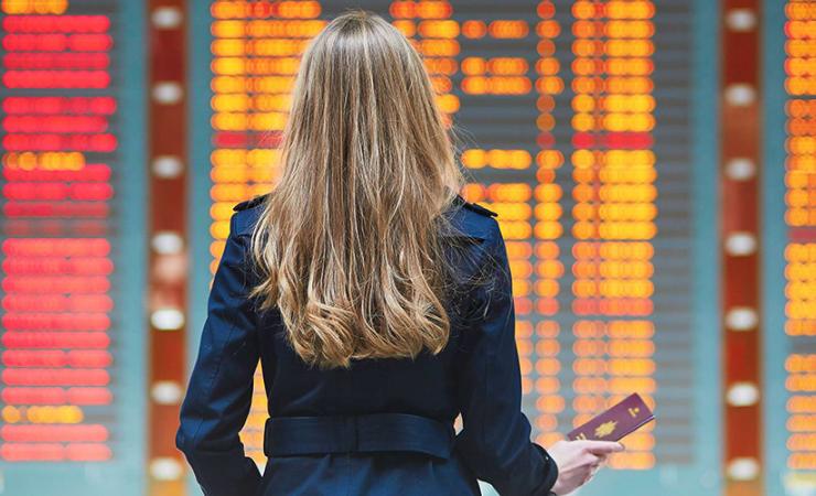 Lady looking at Airport flights notice board