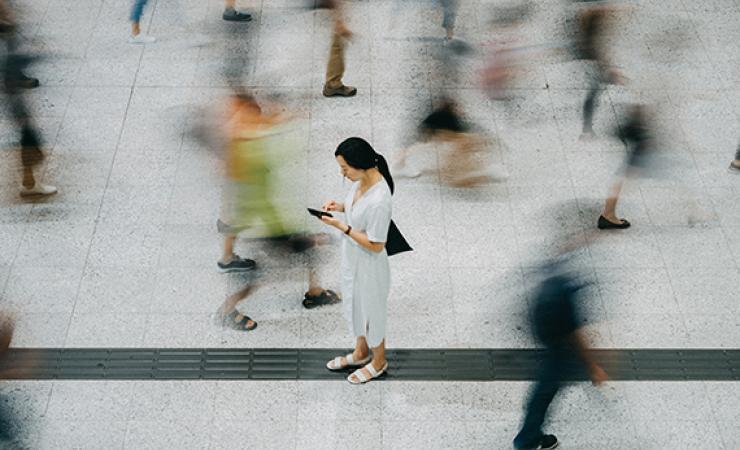 Lady in Airport with people rushing passed