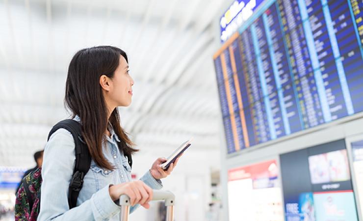 Lady in airport looking at flight board