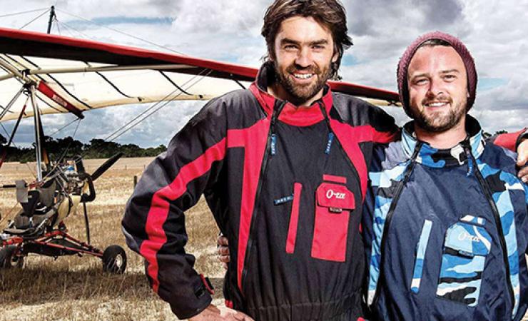 Two men standing in front of an air glider