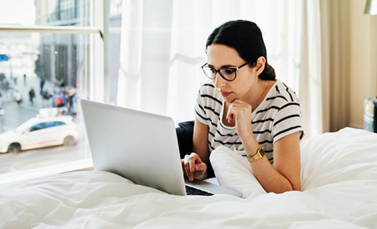 Lady lying on bed with laptop