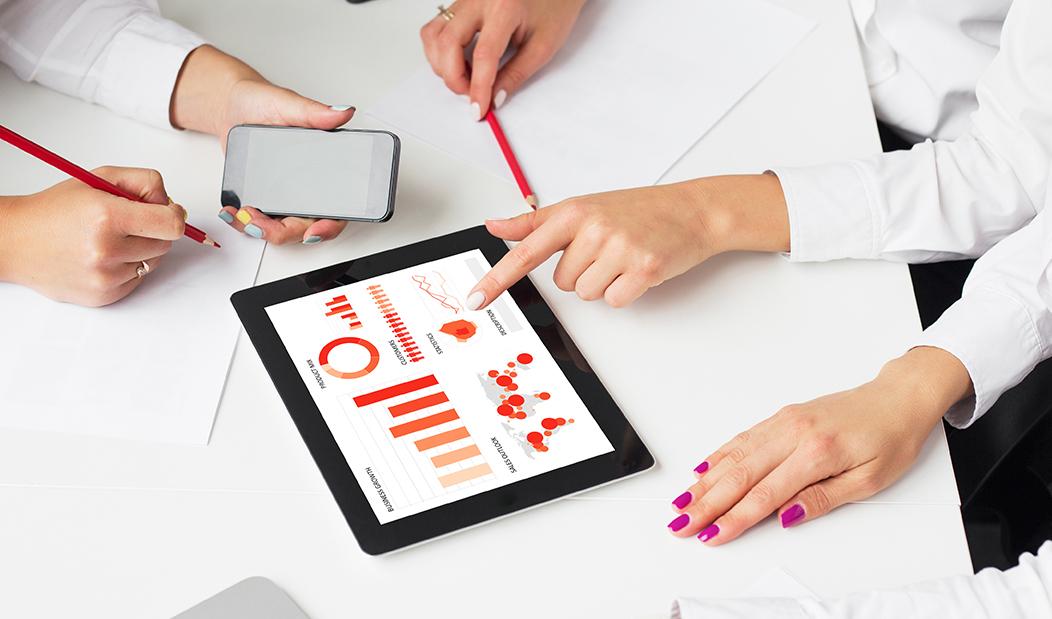 Group of people reviewing report on iPad