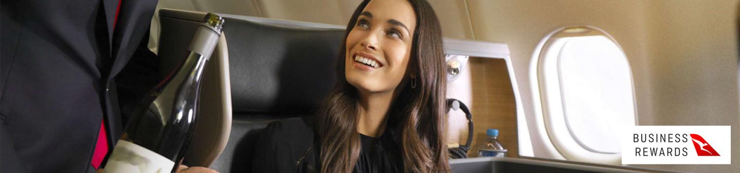 Woman being served wine on Qantas flight