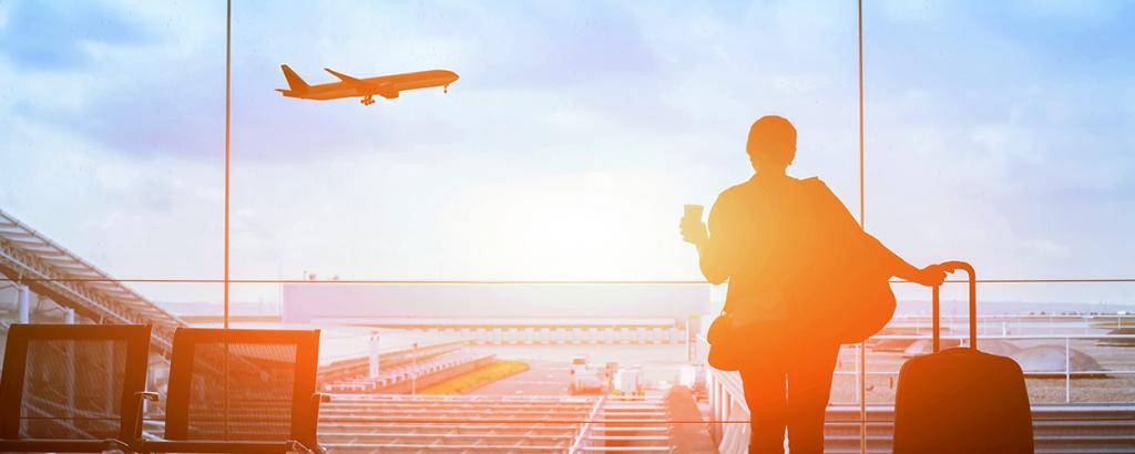 Person in terminal watching plane flying