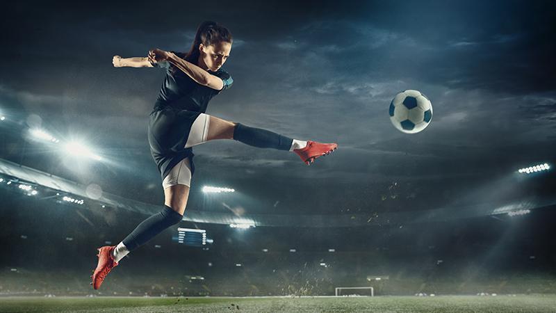 women football player kicking ball